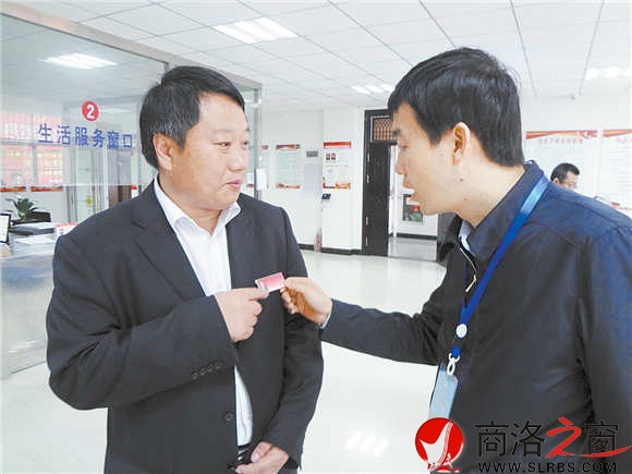 在鎮(zhèn)安縣新城社區(qū)便民服務(wù)大廳里,參會人員對社區(qū)工作人員掛牌上崗很感興趣。(記者 柯巖 攝)